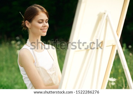 woman young artist paints a picture easel
