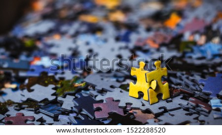 Teamwork concept, two yellow puzzles are walking together after scattered puzzles with blurry background. Royalty-Free Stock Photo #1522288520