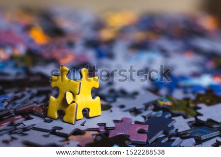 Teamwork concept, two yellow puzzles are walking together after scattered puzzles with blurry background. Royalty-Free Stock Photo #1522288538