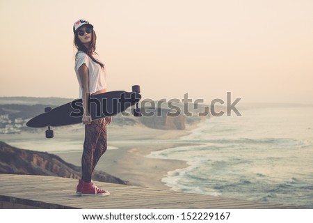 Beautiful and fashion young woman posing with a skateboard Royalty-Free Stock Photo #152229167