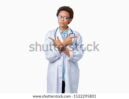 Young african american doctor woman wearing medical coat over isolated background Pointing to both sides with fingers, different direction disagree
