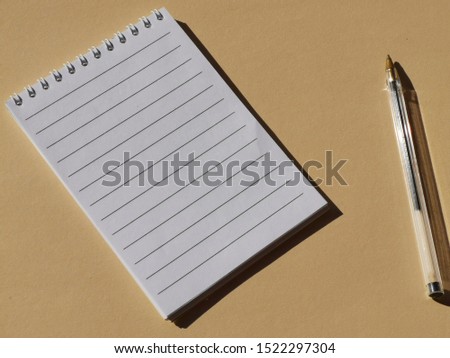 paper book and pencil and brown  background. 

