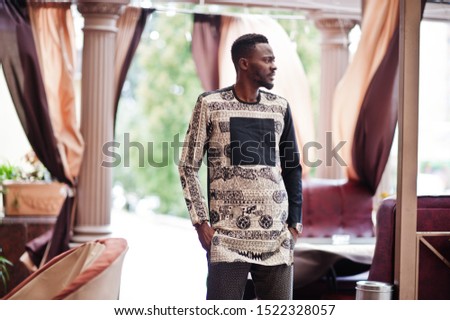 Handsome afro american man wearing traditional clothes in modern city.