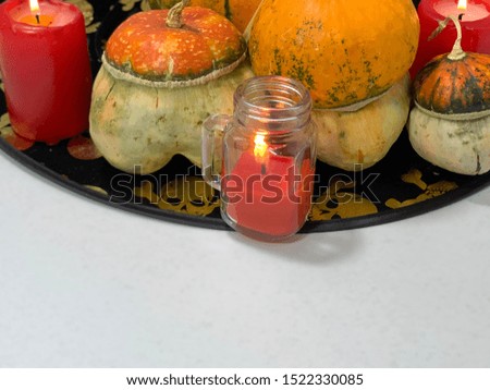 Halloween holiday. Skulls on black fabric. Red burning candles. Good night, horror. Autumn vegetable, veggie food. Decor for the holiday.