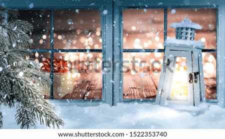 Christmas window, with pine branches, lantern and snow in winter mood 