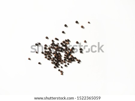 Black peppercorns on white background                               