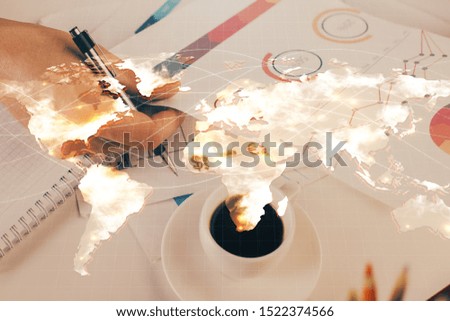 Double exposure of Man writing in notepad with business icons on background.