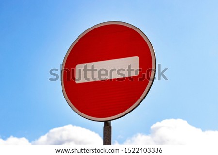 Red and white Do not enter sign on blue sky background
