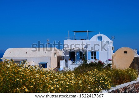 Landscape views of the town of Oia, Santorini, Greece to include buildings, churches,houses, doors, windows, gate and alley ways.  All overlooking the blue Aegean Sea.