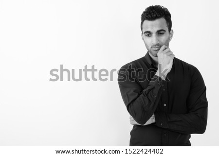 Young handsome Indian businessman against white background