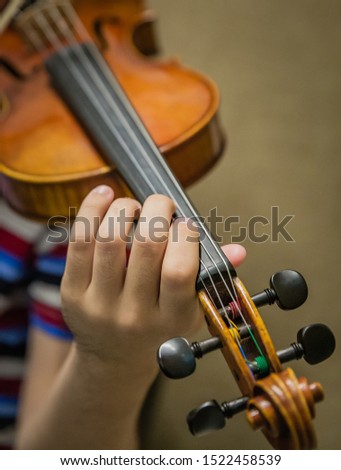 Young student's hands practicing the violin