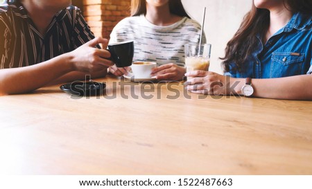 Closeup image of friends enjoyed talking and drinking coffee together in cafe