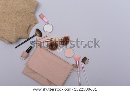 flat lay, clothes with accessories with makeup on gray background, Fashion concept
