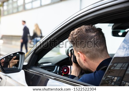 Private Detective Taking Photos Of Man And Woman On Street Royalty-Free Stock Photo #1522522304