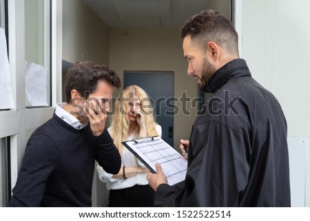 Bailiff Talking With Sad Couple At Home Entrance Royalty-Free Stock Photo #1522522514