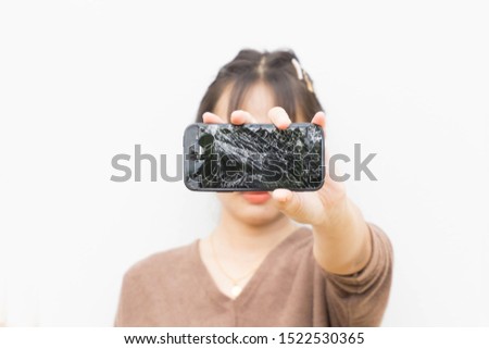 Close-up of Broken Screen Smartphone in hand woman isolated on wall background.