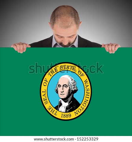 Smiling businessman holding a big card, flag of Washington, isolated on white