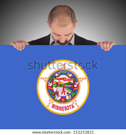 Smiling businessman holding a big card, flag of Minnesota, isolated on white