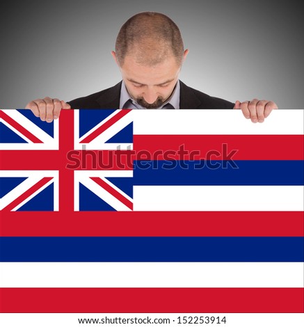 Smiling businessman holding a big card, flag of Hawaii, isolated on white