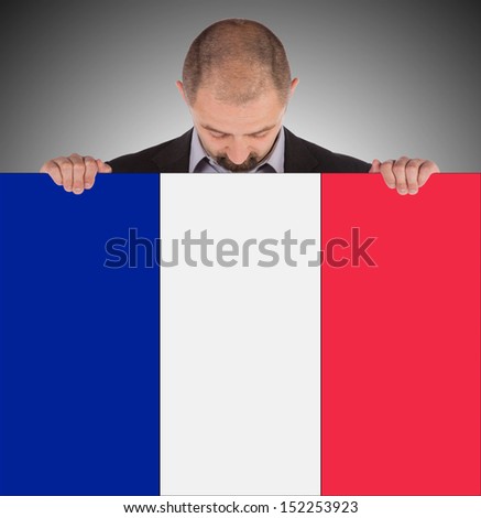 Smiling businessman holding a big card, flag of France, isolated on white