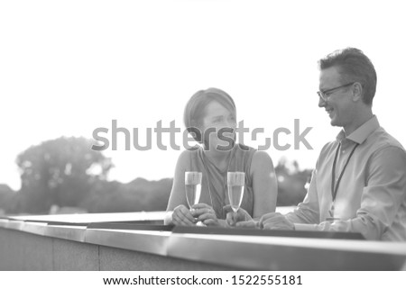 Black and white photo of Mature business colleagues talking at rooftop during success party