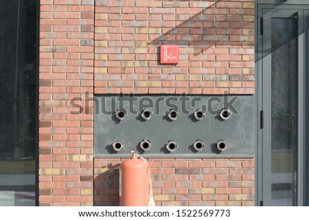 Fire hydrant water emergency system for office buildings in a brick wall.
