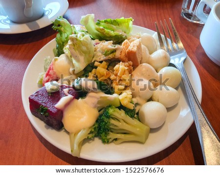 Fresh mixed vegetables salad and eggs in a white plate.