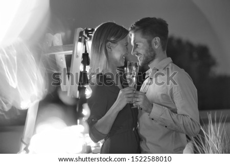 Black and white photo of Smiling young business couple enjoying during rooftop party