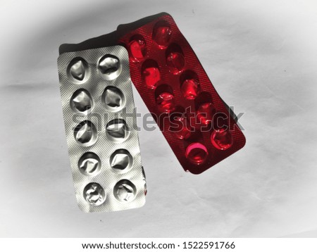 Empty packs of drugs on a white background. Used blisters with red, white and brown foil. Top view.