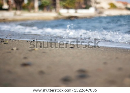 Rocky seashore, sand and wavy blue sea