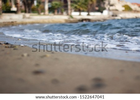 Rocky seashore, sand and wavy blue sea
