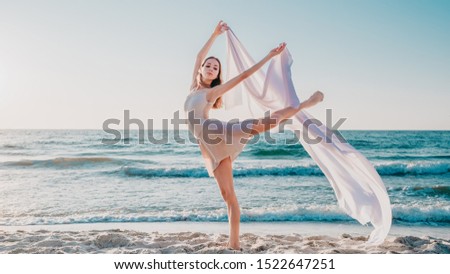 Dancing lady with white cloth on sea background.Nature, ballet,gymnastic concept
