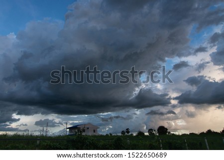 nimbostratus clouds above building and field Royalty-Free Stock Photo #1522650689