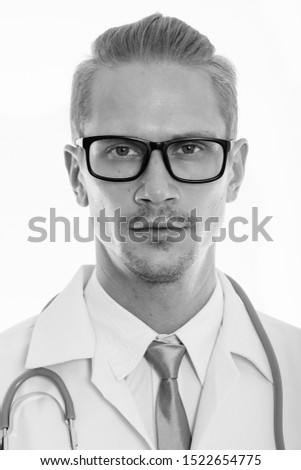 Face of young handsome man doctor wearing eyeglasses