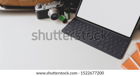 Modern workplace with blank screen tablet with camera and office supplies in modern photographer workplace 