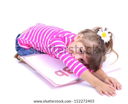 Little girl sitting on floor with book isolated on white