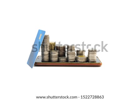Credit cards and silver coins are stacked on a mobile phone, white background and cropped parts.