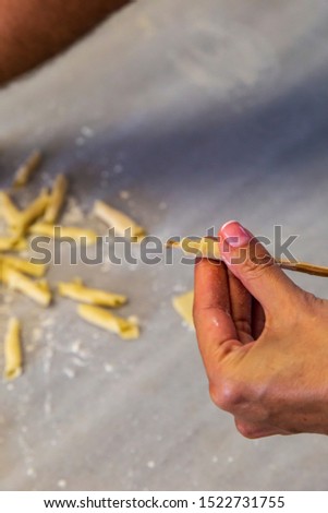 Chef woman's hands making tagliatelle pasta. Cooking process. Raw food photography concept.