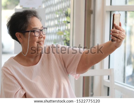 Active and happy senior woman selfie herself with mobile phone.