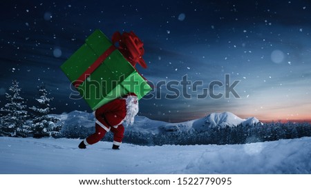 Santa Claus carrying huge christmas gift at night with copy space