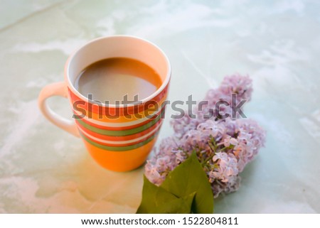 cup of coffee and a branch of flowers
 liliac