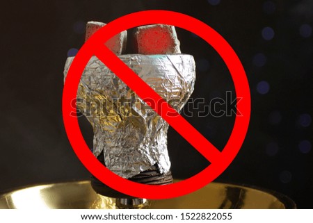 Danger and harm of smoking. Red prohibition sign on hookah with coals