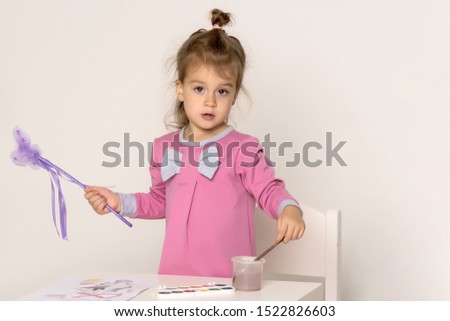 Little girl draws paints.Isolated on white background.