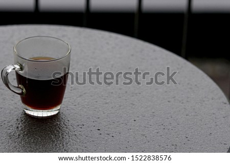 Hot black coffee in clear glass on the table at balcony. Morning cup of hot coffee on the table. soft focus.