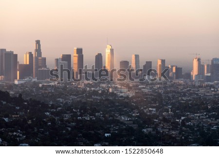 Downtown Los Angeles buildings reflecting early morning sunlight through the haze.
