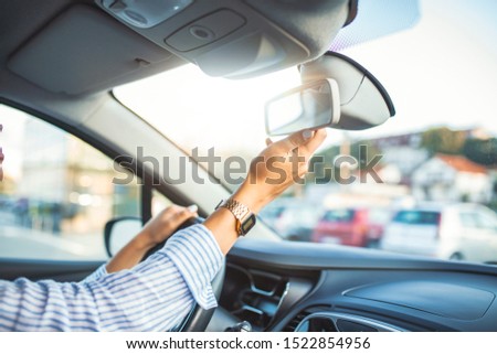 Adjusting the rear view mirror. Hand adjusting rear view mirror. Safety concept. Woman adjusting rear view mirror. 