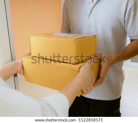 Delivery staff uniform handing a parcel box receiving parcel from delivery