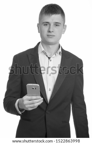 Studio shot of young businessman holding mobile phone
