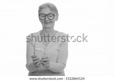 Happy senior nerd woman smiling while using mobile phone