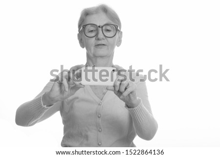 Senior nerd woman taking picture with mobile phone